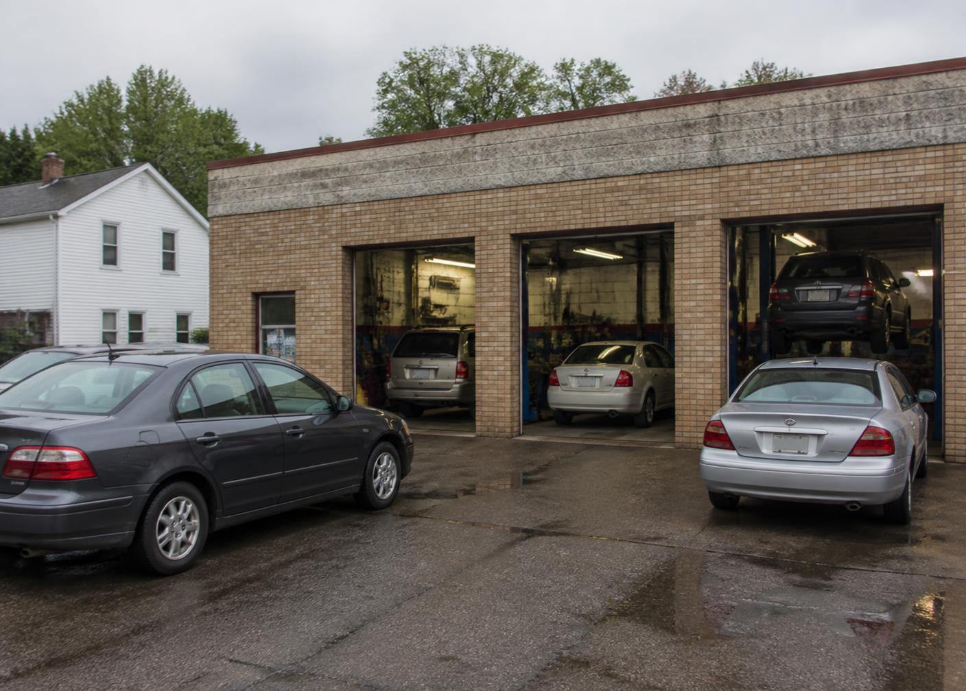Service bays at Callahan's Muffler & Brake in Pontiac, MI with vehicles in for repair